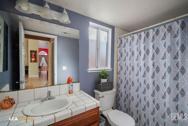 bathroom featuring toilet, curtained shower, and vanity