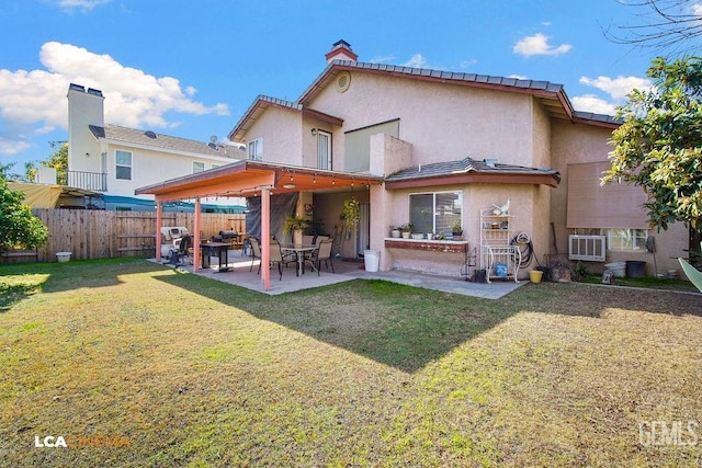 rear view of house with a patio and a lawn