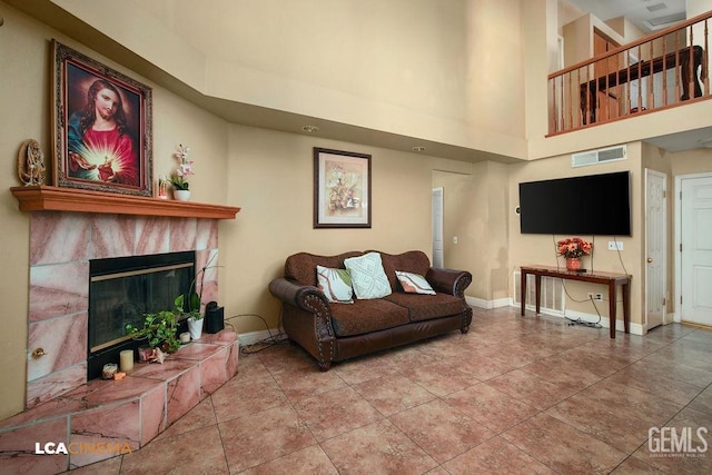 tiled living room with a towering ceiling and a tiled fireplace