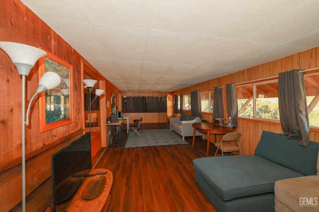 living room featuring dark wood-type flooring and wood walls