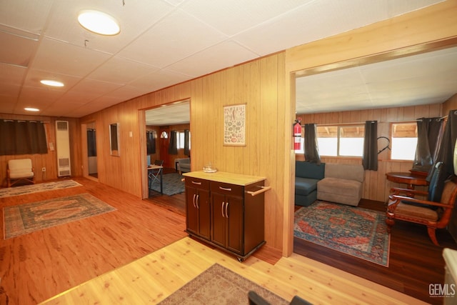 corridor with wooden walls and light hardwood / wood-style flooring