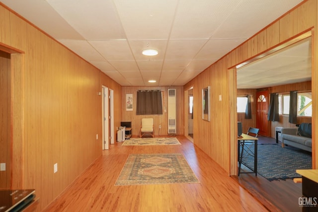 unfurnished living room with light wood-type flooring and wooden walls