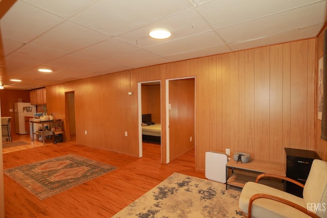 sitting room with light hardwood / wood-style flooring and wood walls