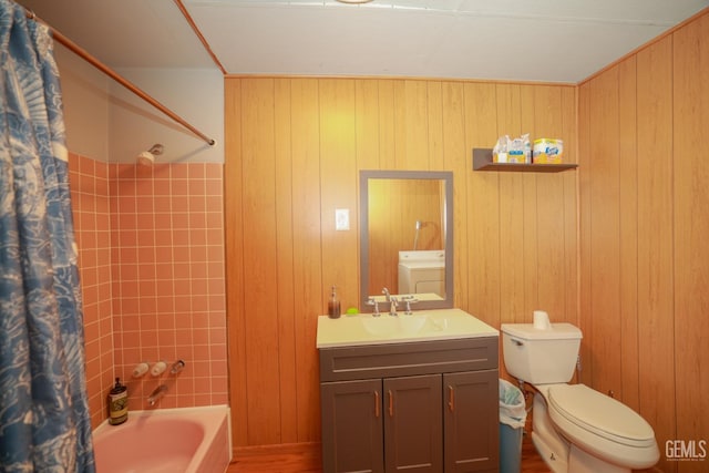 full bathroom with vanity, washer / dryer, wooden walls, and shower / tub combo