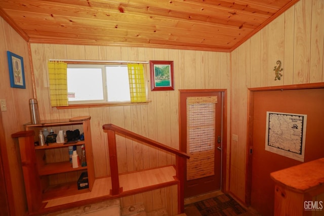 staircase featuring wooden walls, wood ceiling, and vaulted ceiling