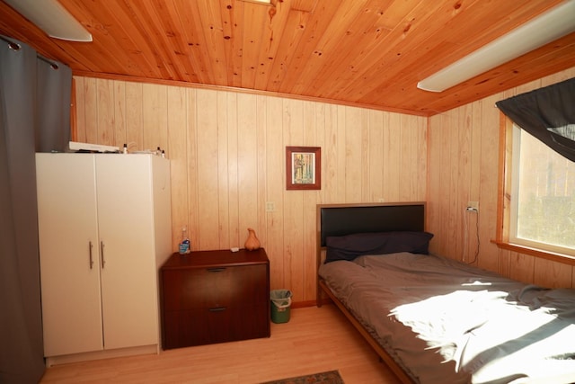 bedroom featuring light hardwood / wood-style floors, wooden ceiling, and wood walls