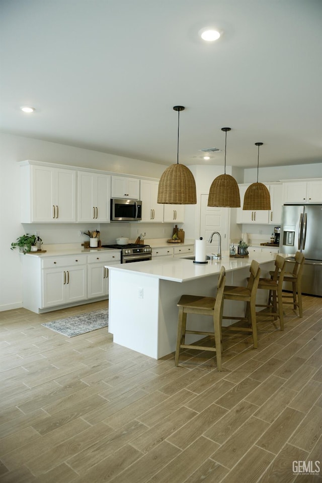 3312 Brook Grove Ln, Shafter, CA 93263 - kitchen with stainless steel appliances, light wood-style floors, recessed lighting, and white cabinets