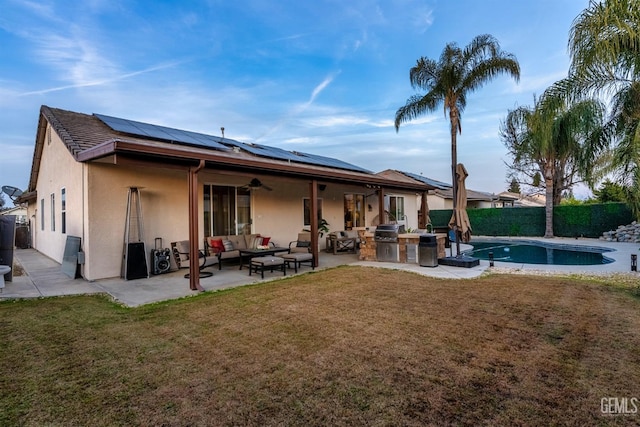 rear view of property with a patio, area for grilling, an outdoor hangout area, a fenced in pool, and solar panels