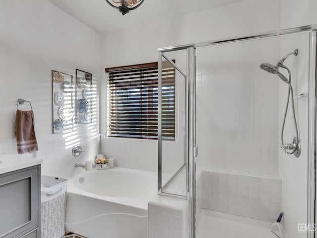 bathroom with vanity and shower with separate bathtub