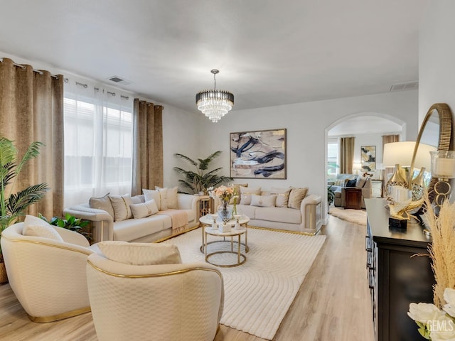 living room with an inviting chandelier and light wood-type flooring