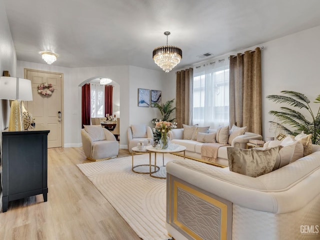 living room featuring a chandelier and light hardwood / wood-style flooring