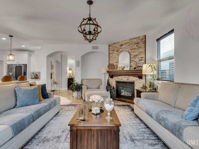 living room with wood-type flooring, a fireplace, and a chandelier