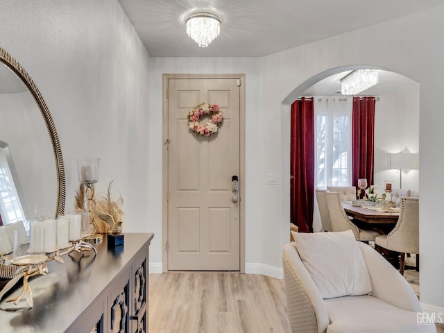 foyer with light wood-type flooring and a chandelier