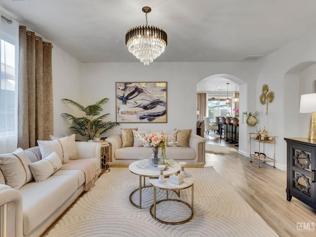 living room featuring an inviting chandelier and light wood-type flooring