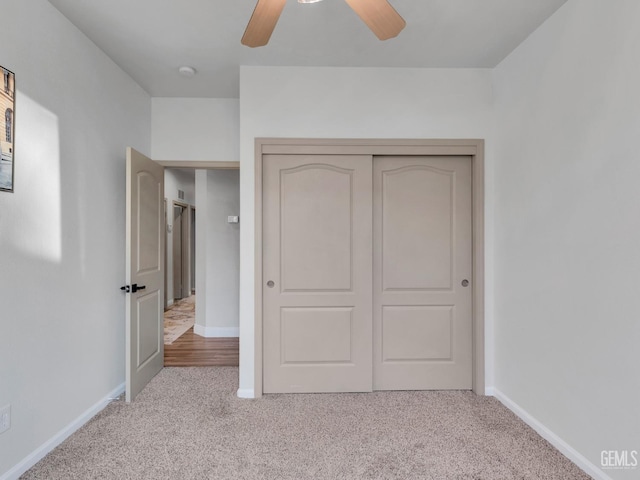 unfurnished bedroom with light carpet, ceiling fan, and a closet