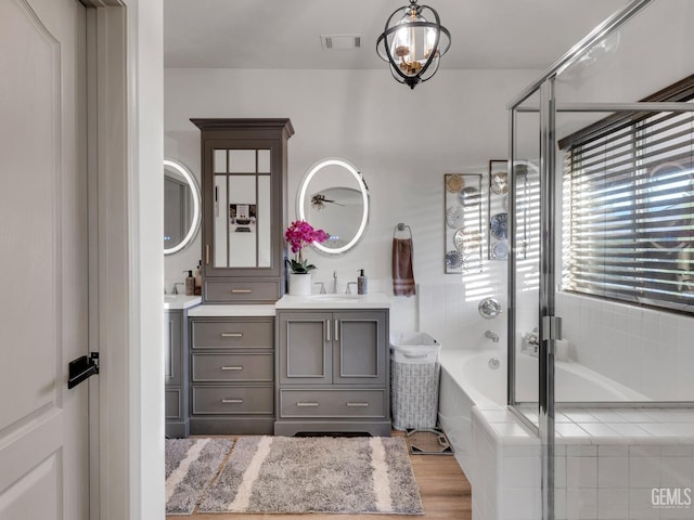 bathroom with hardwood / wood-style flooring, vanity, and separate shower and tub