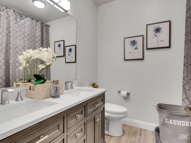 bathroom featuring vanity, hardwood / wood-style floors, and toilet