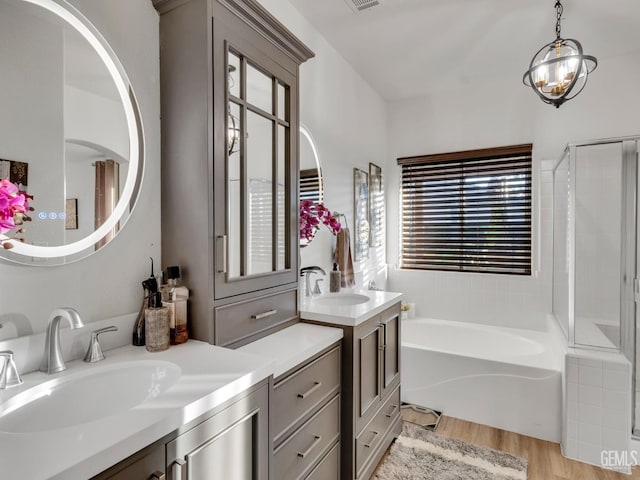 bathroom with wood-type flooring, shower with separate bathtub, and vanity