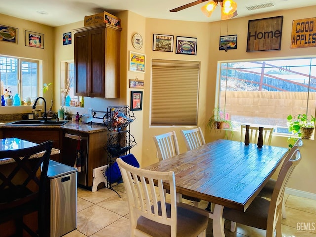 tiled dining area with ceiling fan, sink, and a healthy amount of sunlight