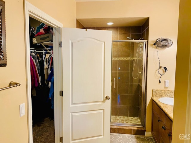 bathroom with tile patterned floors, a shower with door, and vanity