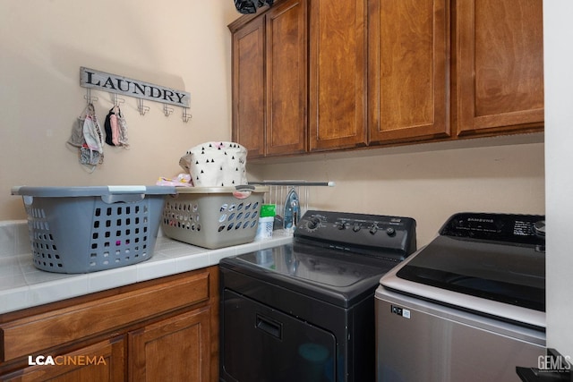 laundry area with washer and dryer and cabinets