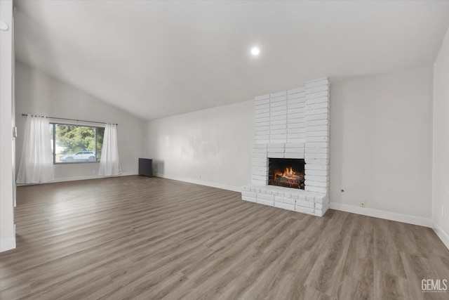 3112 Harrogate Ln, Bakersfield, CA 93309 - unfurnished living room featuring vaulted ceiling, wood finished floors, a brick fireplace, and recessed lighting