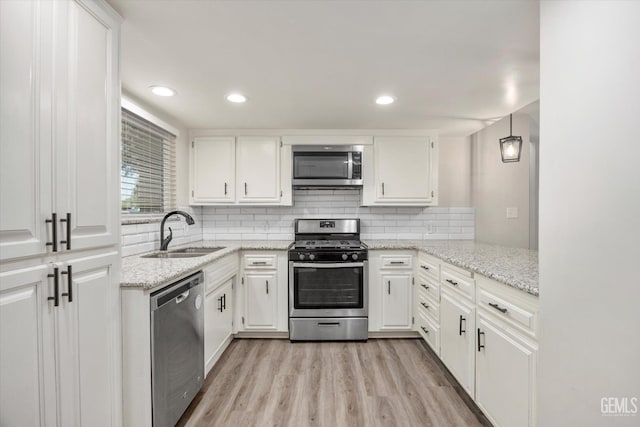 3112 Harrogate Ln, Bakersfield, CA 93309 - kitchen with appliances with stainless steel finishes, white cabinets, light wood-style flooring, and recessed lighting