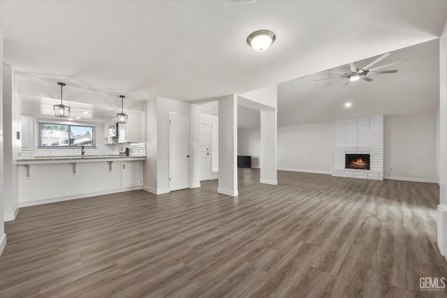 3112 Harrogate Ln, Bakersfield, CA 93309 - unfurnished living room featuring wood finished floors, a brick fireplace, a ceiling fan, and lofted ceiling