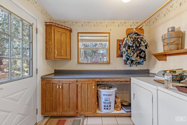 laundry area featuring cabinets, light tile patterned floors, and washer and dryer