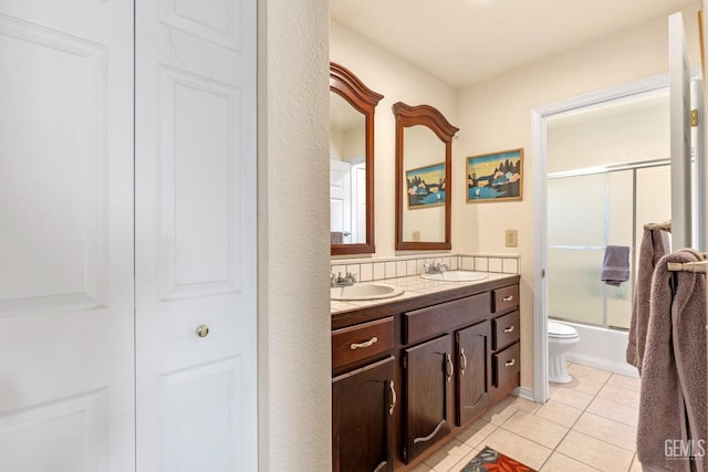 full bathroom featuring vanity, toilet, tile patterned flooring, and combined bath / shower with glass door