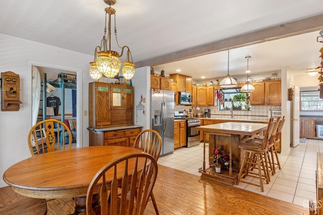 tiled dining room with a notable chandelier and sink