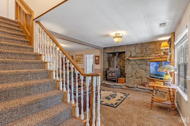 interior space featuring carpet flooring, a wood stove, and a wealth of natural light