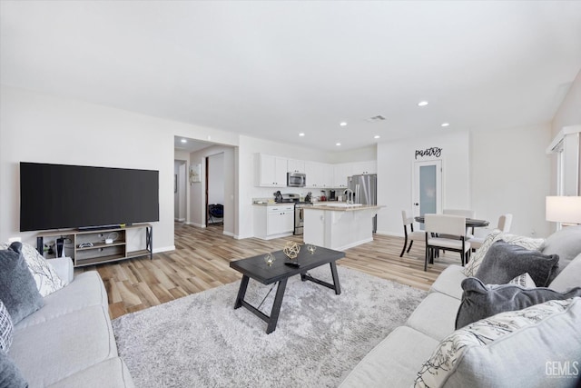 5711 Cordonata Way, Bakersfield, CA 93306 - living area with light wood finished floors, recessed lighting, and baseboards