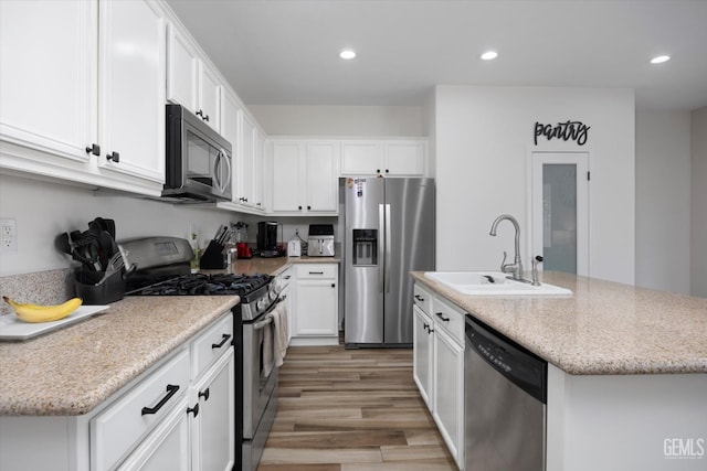 5711 Cordonata Way, Bakersfield, CA 93306 - kitchen featuring stainless steel appliances, a sink, light wood-type flooring, recessed lighting, and white cabinets