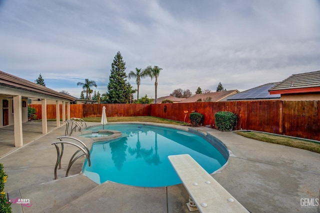 view of swimming pool featuring an in ground hot tub, a diving board, and a patio area