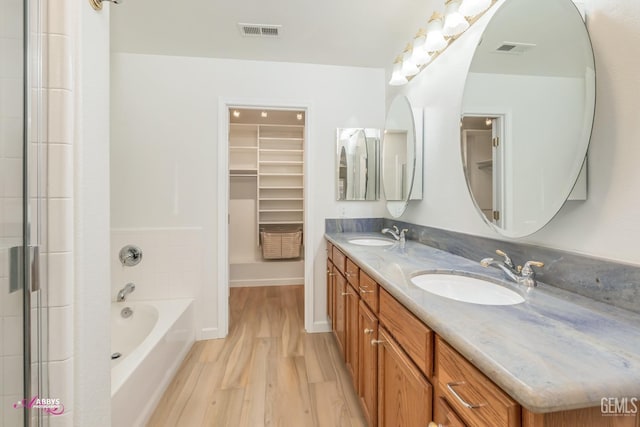 bathroom featuring vanity, separate shower and tub, and wood-type flooring