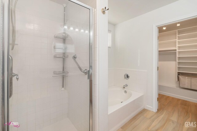 bathroom with hardwood / wood-style floors and independent shower and bath