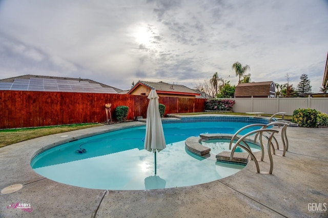 view of swimming pool with an in ground hot tub