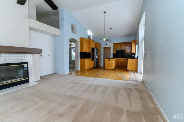 kitchen with light carpet, tasteful backsplash, black fridge, and hanging light fixtures