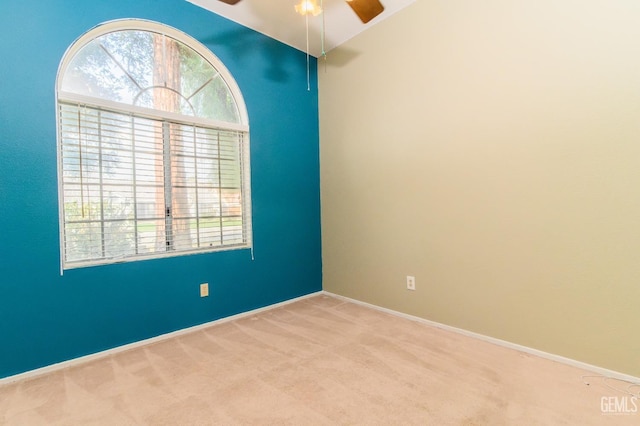 carpeted empty room featuring vaulted ceiling, plenty of natural light, and ceiling fan