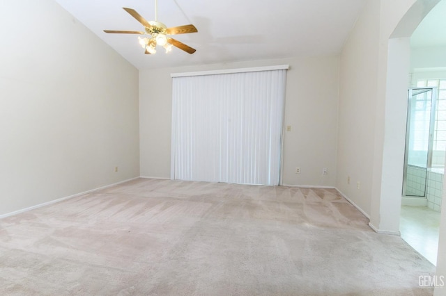 unfurnished bedroom featuring connected bathroom, ceiling fan, light colored carpet, and lofted ceiling