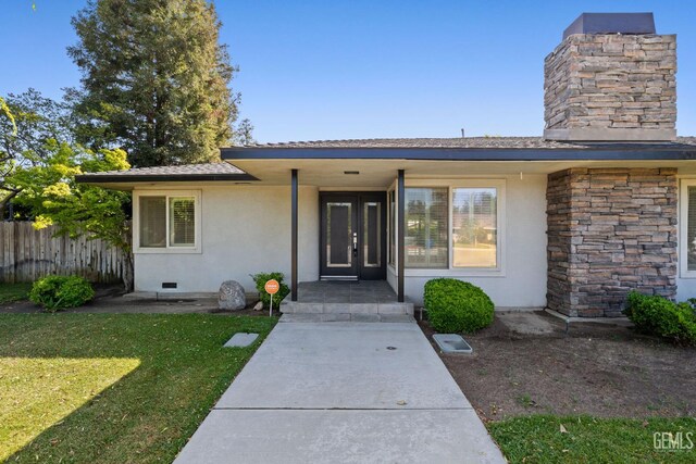 2330 Myrtle St, Bakersfield, CA 93301 - view of exterior entry featuring stucco siding, a chimney, stone siding, and crawl space