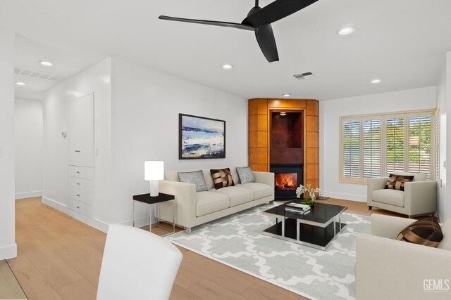 2330 Myrtle St, Bakersfield, CA 93301 - living room featuring light wood-style flooring, a ceiling fan, a tiled fireplace, recessed lighting, and baseboards