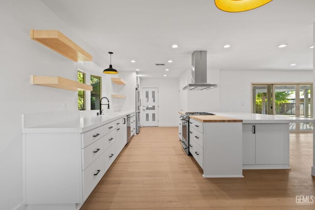 2330 Myrtle St, Bakersfield, CA 93301 - kitchen featuring ventilation hood, appliances with stainless steel finishes, open shelves, white cabinetry, and light wood-style floors