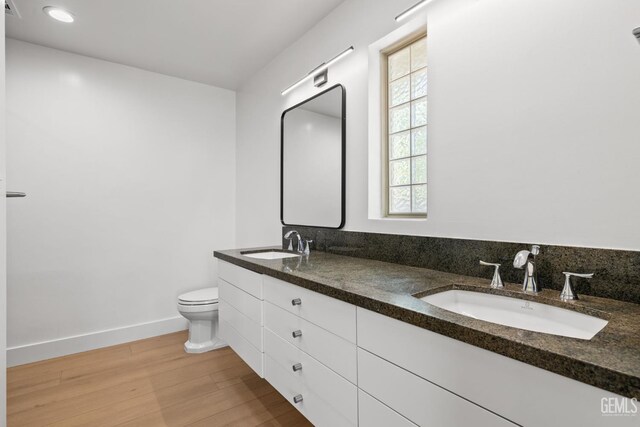 2330 Myrtle St, Bakersfield, CA 93301 - full bath featuring wood finished floors, toilet, double vanity, and baseboards