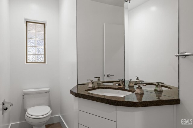 2330 Myrtle St, Bakersfield, CA 93301 - half bathroom featuring toilet, baseboards, and vanity