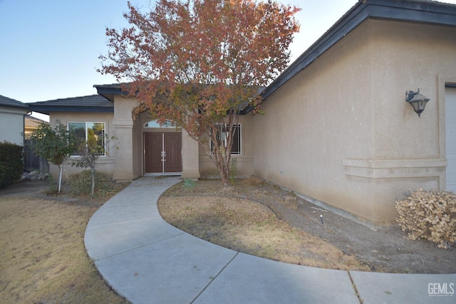 doorway to property featuring stucco siding