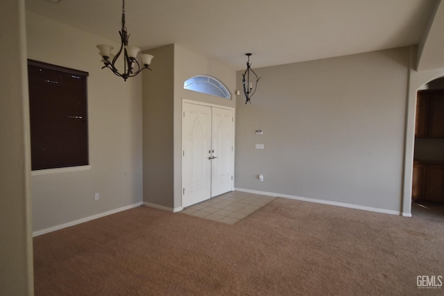 interior space with an inviting chandelier, carpet, and baseboards