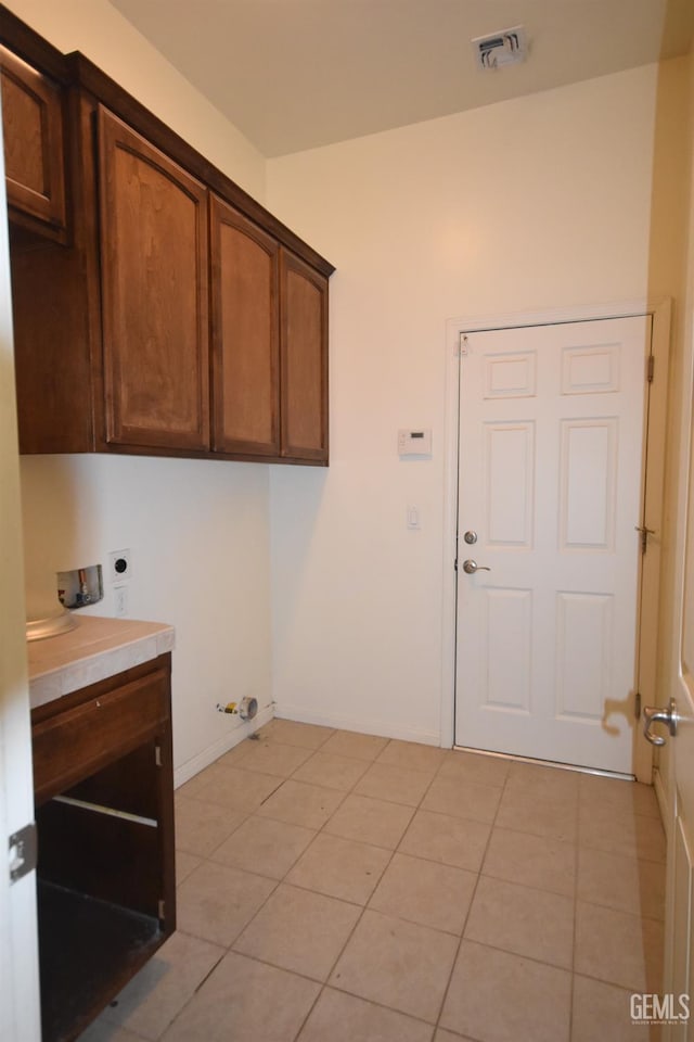 clothes washing area with washer hookup, visible vents, cabinet space, light tile patterned flooring, and electric dryer hookup