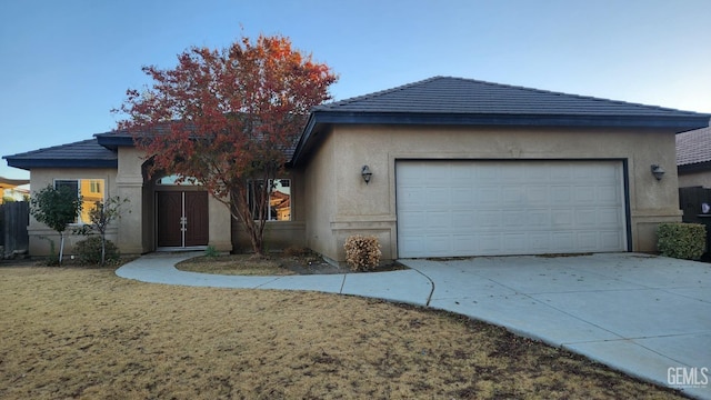 view of front facade featuring a garage, driveway, and stucco siding